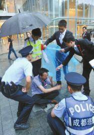 6月13日,成都大慈寺附近,保安张光建和同事及民警帮助坐在雨中的老赵.